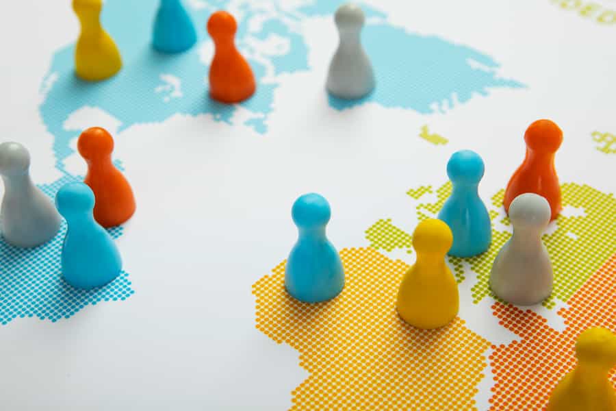 Closeup of colorful wooden pawns on interconnected circles on the map of the world | The Place Of Effective Management And Taxation Of Multinational Companies In Kenya | Netsheria Article